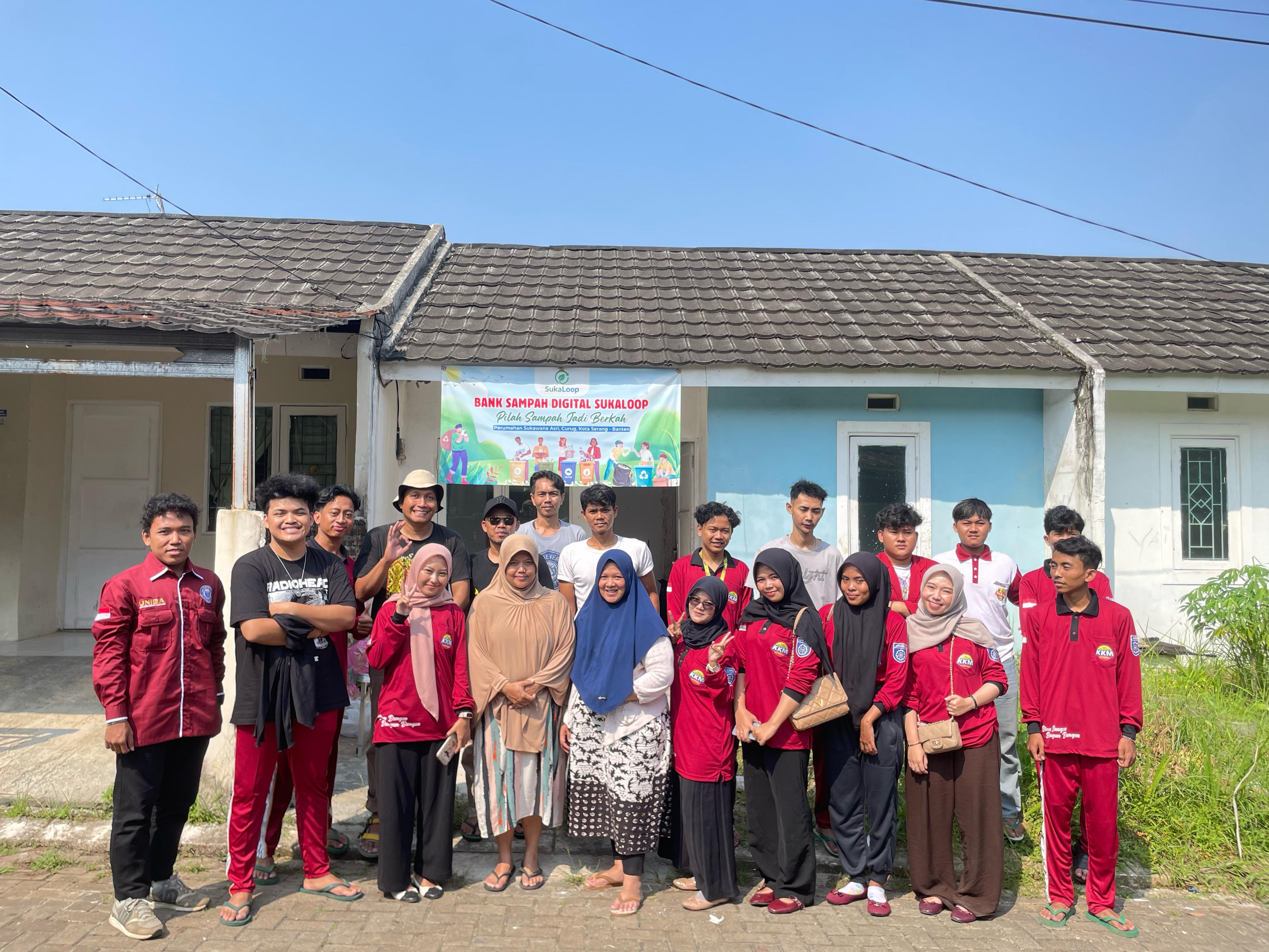 Relawan SukaLoop di depan banner Bank Sampah Digital